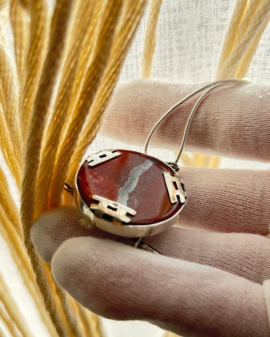 pendentif en argent vue de dos, sertissage par trois torii en argent rabattus sur la pierre. Poinçon.