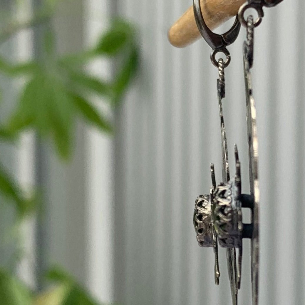 Ces boucles en argent sont constituées de deux plaques superposées et soudées avec un écart afin que la fleur centrale soit surélevée. Au  creux de cette fleur repose un serti e vésuvianite d'un vert éclatant. Inspiré des motifs hatayi. vue de profil. Crochets d'oreille à clips en argent.